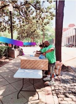 A diverse group of people representing different cultures standing in front of a table.