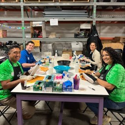 A diverse group of people sitting at a table in a vibrant warehouse, showcasing cultural diversity.